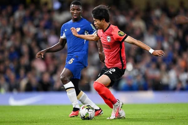 Kaoru Mitoma of Brighton & Hove Albion controls the ball whilst under pressure from former teammate Moises Caicedo of Chelsea