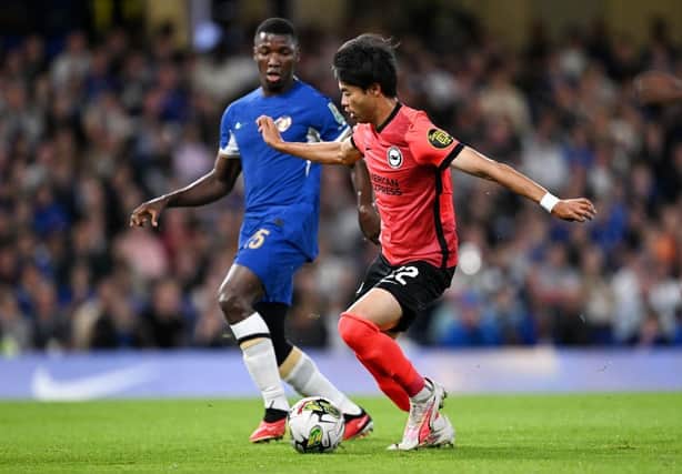 Kaoru Mitoma of Brighton & Hove Albion controls the ball whilst under pressure from former teammate Moises Caicedo of Chelsea