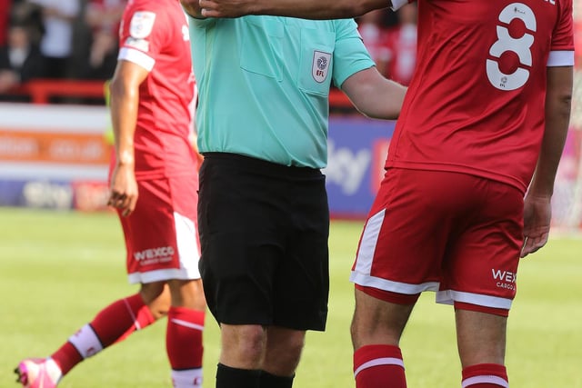 Referee Lee Swabey shows a yellow card to Jack Powell of Crawley Town.