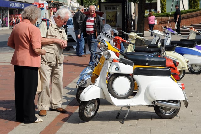 Taking a keen interest in the scooters on show in South Street Square