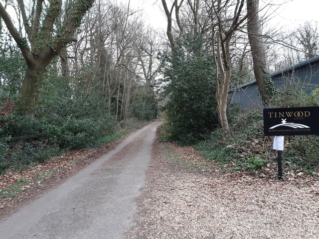 Follow the road past the Tinwood entrance. This becomes an unmade path, which you follow to a kissing gate.