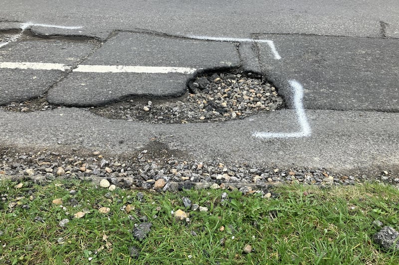Deep potholes rutting St Leonard's Road in Horsham are by verges and in the middle making it difficult for vehicles to avoid them