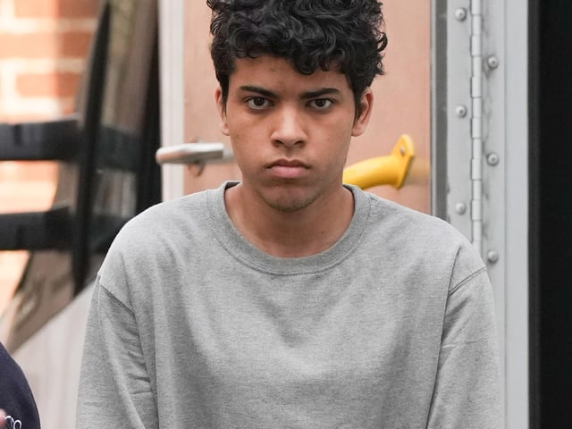 A Sussex teenager accused of murdering his father and attempting to kill a woman and a boy has been pictured arriving at court in handcuffs.