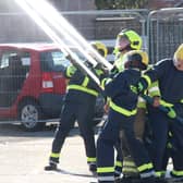 Students from Oak Grove College squirt water at a drill tower to simulate a house fire being extinguished. Picture courtesy of West Sussex Fire & Rescue Service