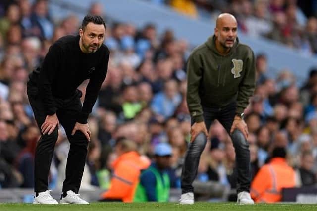 Brighton's Italian head coach Roberto De Zerbi (L) and Manchester City's Spanish manager Pep Guardiola watch on during the Premier League match at the Etihad Stadium