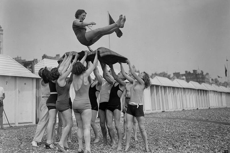 Day trippers give the bumps to the birthday girl at Brighton seaside resort on 5th June 1930.