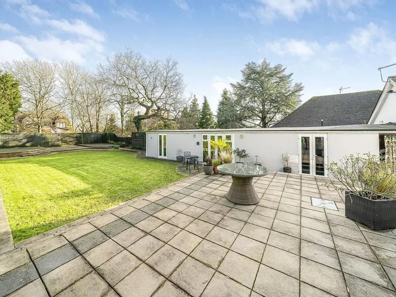 Outside there is a large lawn and a spacious patio from the kitchen