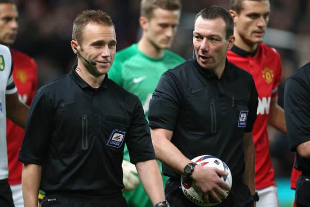 Referee Kevin Friend talks to his assistant referee Harry Lennard during the Capital One Cup Fourth Round match between Manchester United and Norwich City at Old Trafford on October 29, 2013 in Manchester, England.  (Photo by Clive Brunskill/Getty Images)