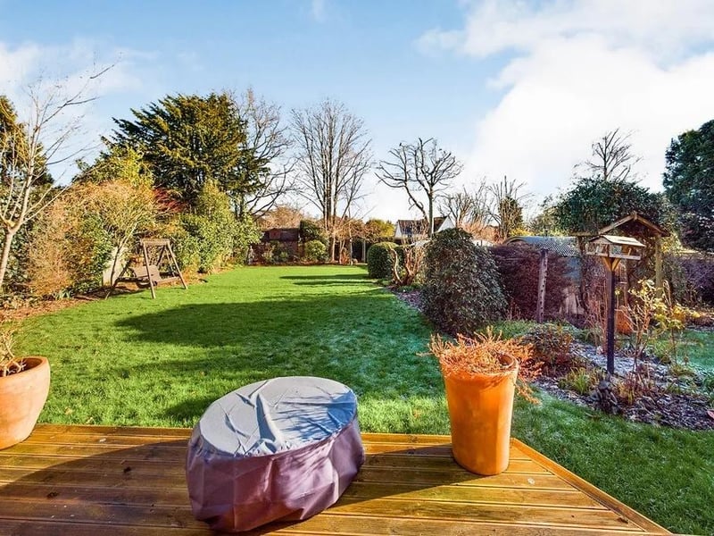 At the rear there is a raised decking platform that leads out into a mostly lawned area of garden