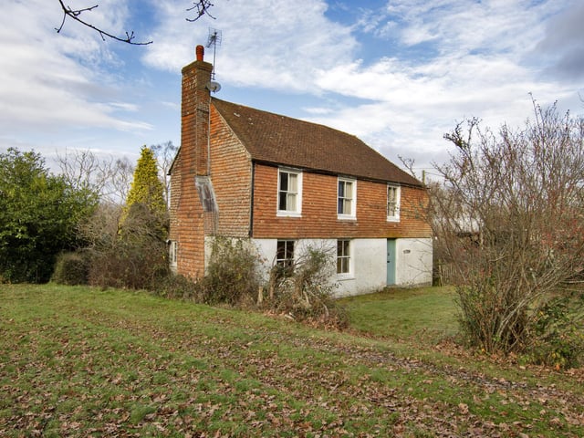 A farmhouse with farm buildings set within 119 acres on the edge of the Ashdown Forest is on the market