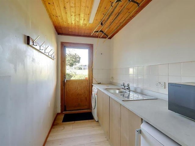 The utility room has a sink and space for a washing machine