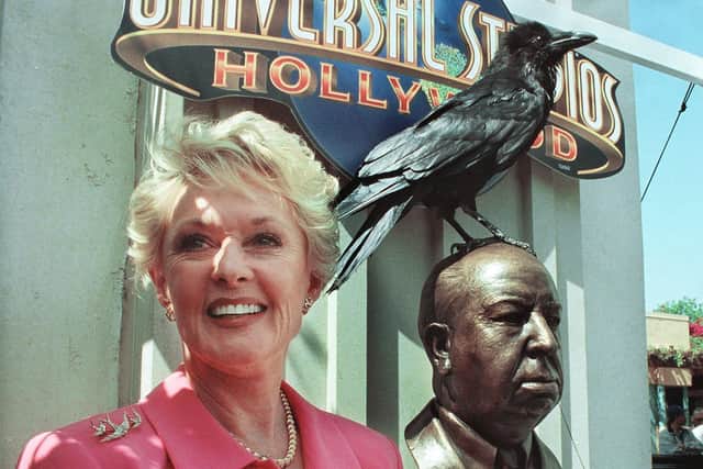 Former actress Tippi Hedren who starred in the movie The Birds stands next to a bronze bust of the late director Alfred Hitchcock during a 1999 ceremony at Universal Studios in Los Angeles, California.  (Photo by SCOTT NELSON/AFP via Getty Images)
