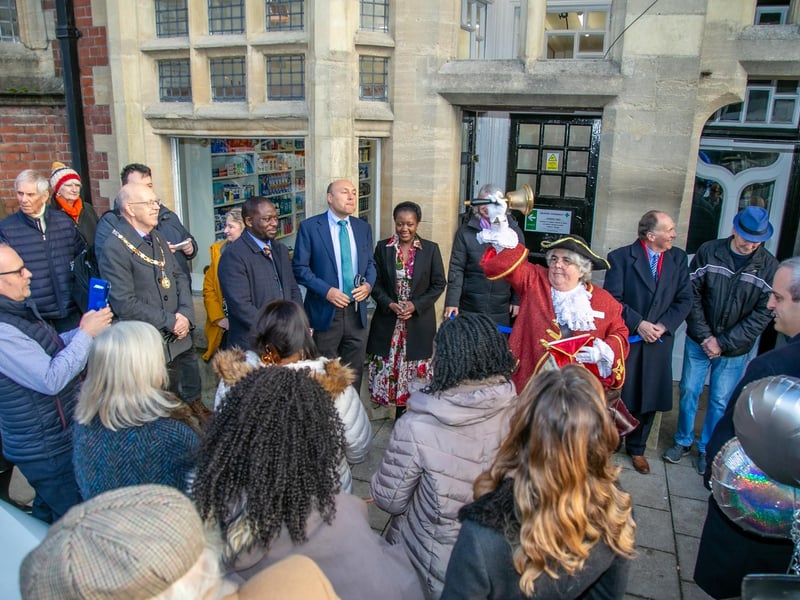 Angela Standing, town crier, rings her bell at the pharmacy opening