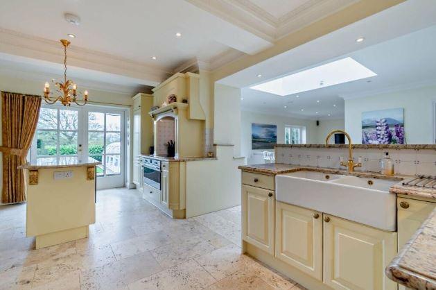 The kitchen is fitted with classic cabinetry and stone work surfaces, with integrated appliances, an island unit and a double Belfast sink. Ancillary space is provided by adjoining larder, utility and freezer rooms.