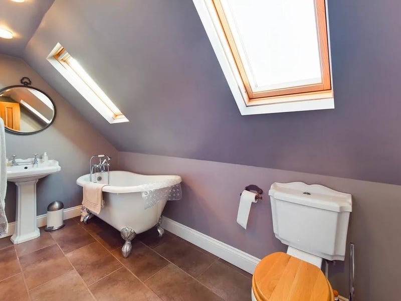 One of the bathrooms has a refitted white suite that includes a roll edged cast iron bath on feet
