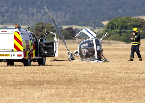 A helicopter on its side following a crash at Goodwood Aerodrome today