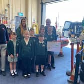 White Meadows School Council representatives present RNLI volunteers with monies they raised.