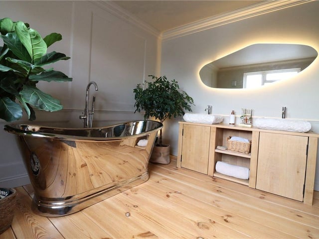 The family bathroom has a copper freestanding bath and fully-tiled shower room