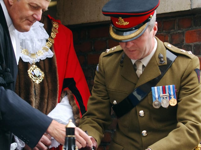 Lieutenant Colonel Mike Kelly, Commanding Officer of 47th Regiment Royal Artillery, signs the Certificate of Freedom in the presence of Rodney Duggua, town clerk