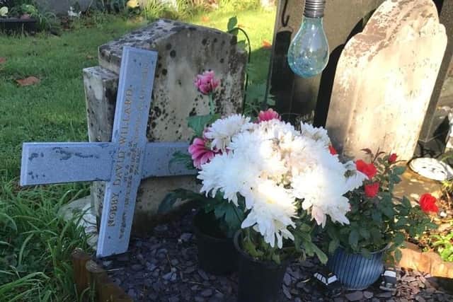 The cross which the family said was ripped out of the ground and left dumped by the grave