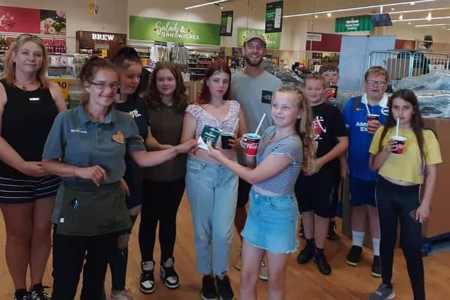 Children and leaders from The Sid Youth CIC collecting their £150 voucher from Morrisons Worthing community champion Joanne Easey