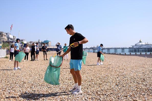 Ryan Peniston of Great Britain participating in a beach clean on Eastbourne seafront during Day Two of the Rothesay International Eastbourne