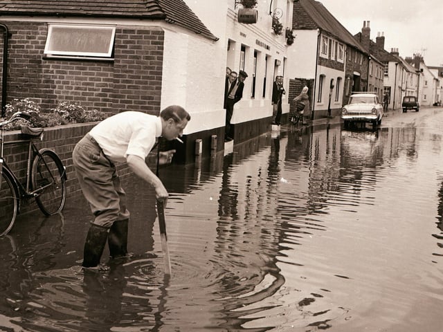 Measuring the depth of the flood water in Tarring High Street in September 1968