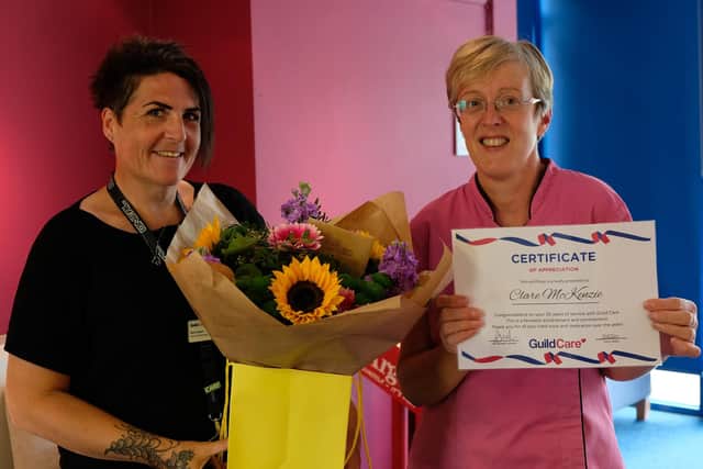 Clare McKenzie being presented with a certificate and bouquet of flowers by Kerry Helyar, home care manager