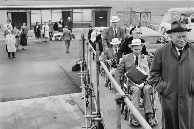 German neurologist Ludwig Guttmann (1899 - 1980) leads members of the Britain's team, en route to Perth for the '1962 Commonwealth Paraplegic Games', on the passenger gangway at Gatwick Airport, UK, 6th November 1962. (Photo by Keystone/Hulton Archive/Getty Images)