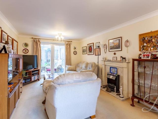 The main room on the ground floor of the property is this homely living room, where the main focal point is a feature fireplace with surround. At the far end are patio doors that lead into the conservatory