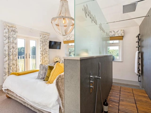 The principal bedroom features a wall divide with a shower space
