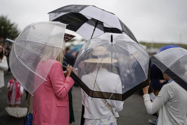 Racegoers take cover at Goodwood - before racing is abandoned three races early | Photo by Alan Crowhurst/Getty Images