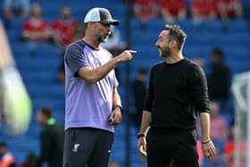 Liverpool's German manager Jurgen Klopp (L) shares a moment with Brighton's Italian head coach Roberto De Zerbi (R)