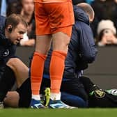 Brighton's Solly March covers his face before being stretchered off injured at Manchester City