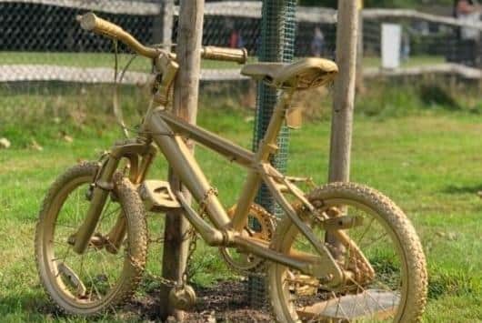 A golden bike under a Giant Gold Bow at Hassocks Goes Gold 2022