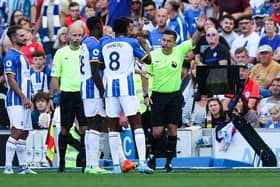 Referee Tony Harrington (R) speaks with Brighton's players as he disallows their third goal scored by Brighton's Argentinian midfielder Alexis Mac Allister in their Premier League match against Leicester