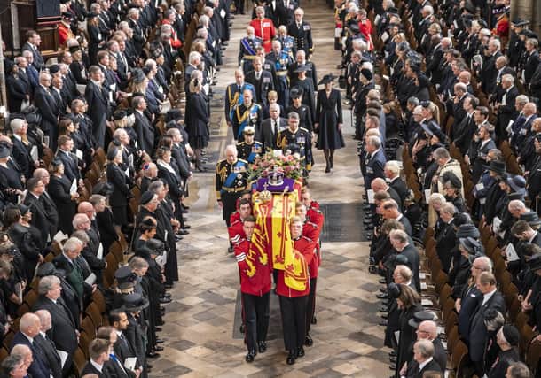 The coffin of Queen Elizabeth II, draped in the Royal Standard with the Imperial State Crown and the Sovereign's orb and sceptre, is carried out of Westminster Abbey after her state funeral on Monday (September 19). Photograph: Danny Lawson/ WPA Pool/Getty Images