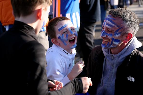 A family of Brighton & Hove Albion fans apply face paint outside the stadium