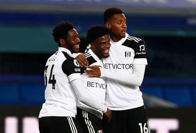 Josh Maja of Fulham celebrates with teammates Ola Aina and Tosin Adarabioyo after scoring their side's second goal during the Premier League match between Everton and Fulham at Goodison Park on February 14, 2021.