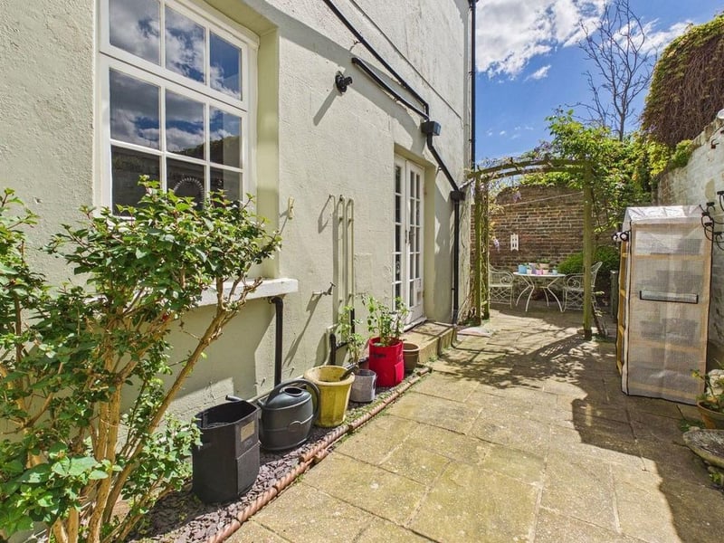 There is a patio seating area with slate shingle borders and a side return to the front of the property