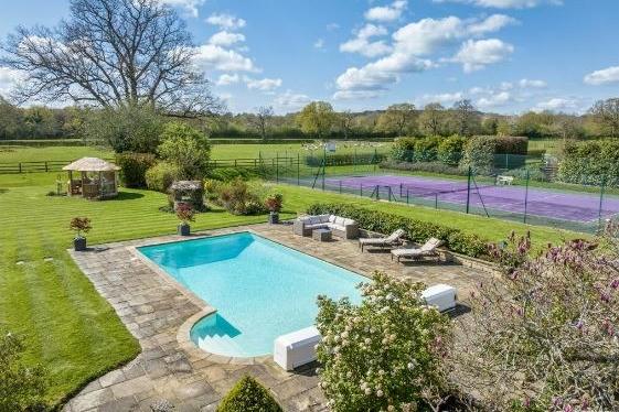 The outdoor swimming pool and tennis court