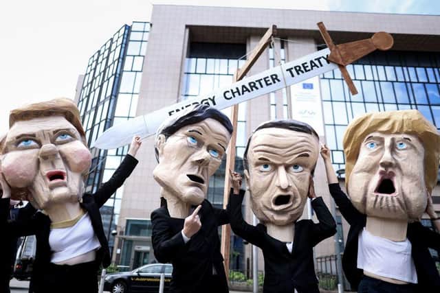 Environmental activists, wearing masks mimicking EU leaders (L/R): EU Commission President Ursula von der Leyen, Netherlands' Prime Minister Mark Rutte, France's President Emmanuel Macron and Germany's Chancellor Angela Merkel, pose outside the European Council building in Brussels on July 6, 2021. - Four hundred worldwide civil society organisations have sent an open letter to EU leaders to call on the EU and its member states to exit the threat of the Energy Charter Treaty (ECT) by the UN Climate Summit in November 2021 in Glasgow. (Photo by Kenzo TRIBOUILLARD / AFP) (Photo by KENZO TRIBOUILLARD/AFP via Getty Images)