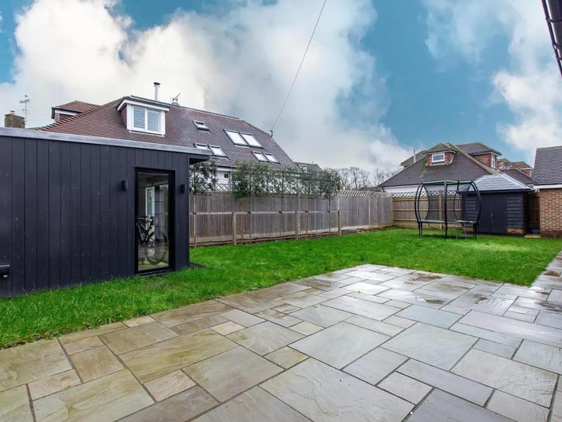 The rear garden has been landscaped with a level lawn and a paved terrace