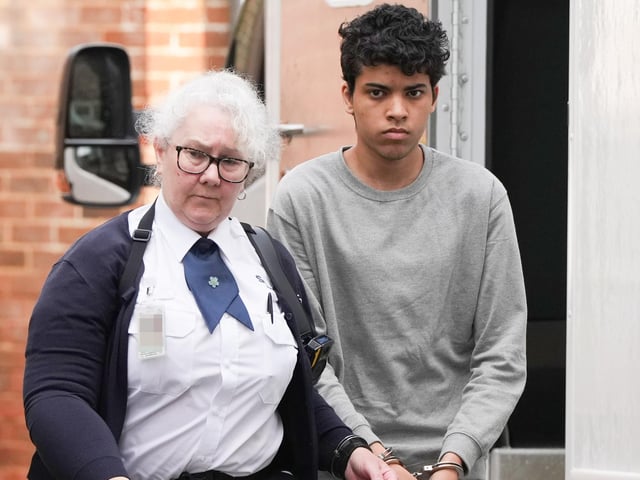 A Sussex teenager accused of murdering his father and attempting to kill a woman and a boy has been pictured arriving at court in handcuffs.