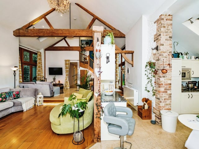The open-plan space has a high vaulted ceiling with exposed timber beams