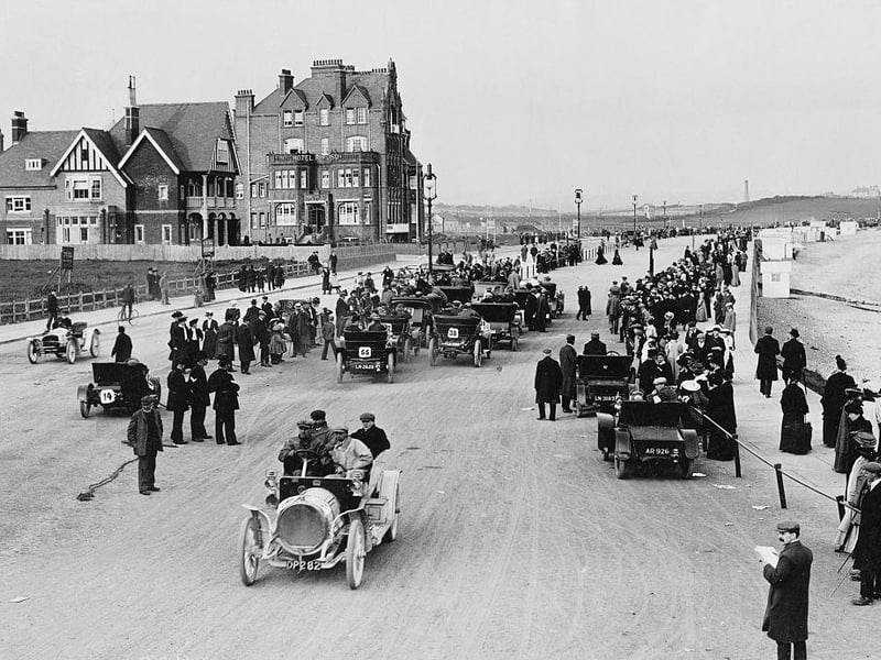 Spectators watch from the roadside as cars gather to race along the sea shore for the Bexhill quarter mile motor race on 21 May 1907 at Bexhill on Sea,