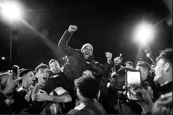 Miles Rutherford is held aloft by his players after promotion is won | Picture: Neil Holmes