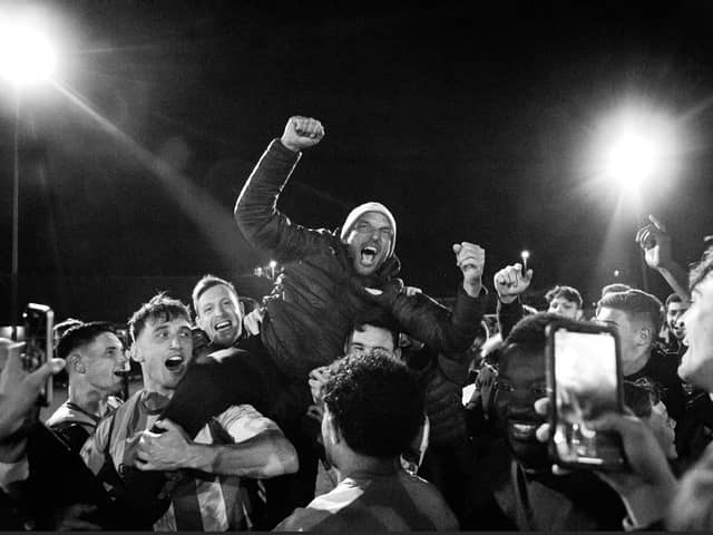 Miles Rutherford is held aloft by his players after promotion is won | Picture: Neil Holmes