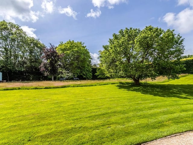 The secluded property has a paddock, formal gardens, mature trees and a large lawned area