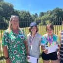 From left to right  Lizzie Robinson-Charlton (Gatwick Airport) presents the 2 winning pupils with boarding pass and medals, and Class 3 teacher Katie Foley from Atelier 21